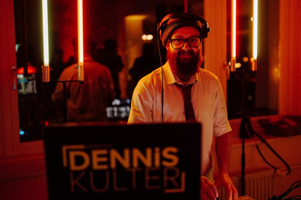 DJ Dennis Külter Portrait mit Kopfhörern und Neon Tubes im Alt Linzens Häuschen – Foto: Björn Schreiber