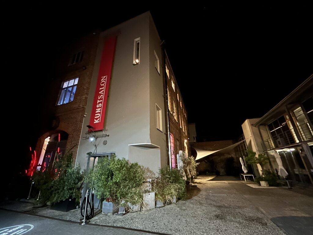 Innenhof des Kunstsalon Köln bei Nacht mit beleuchteter Fassade